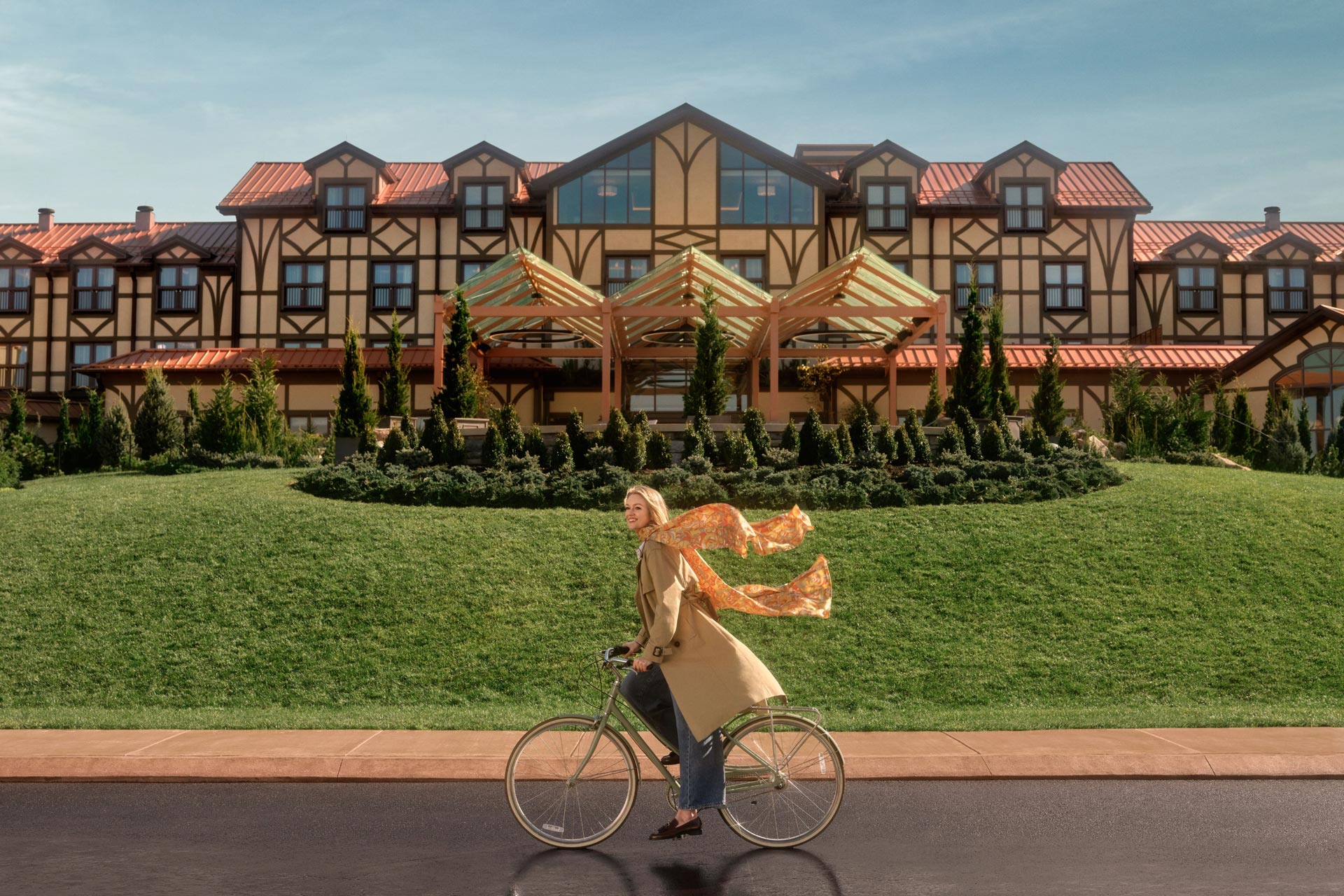 Open gallery overlay: a woman riding a bicycle with her scarf blowing in the wind